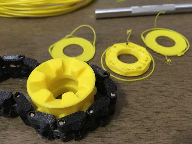 Slightly different yellow color of PLA filament. Tracks wrapped around the wheel